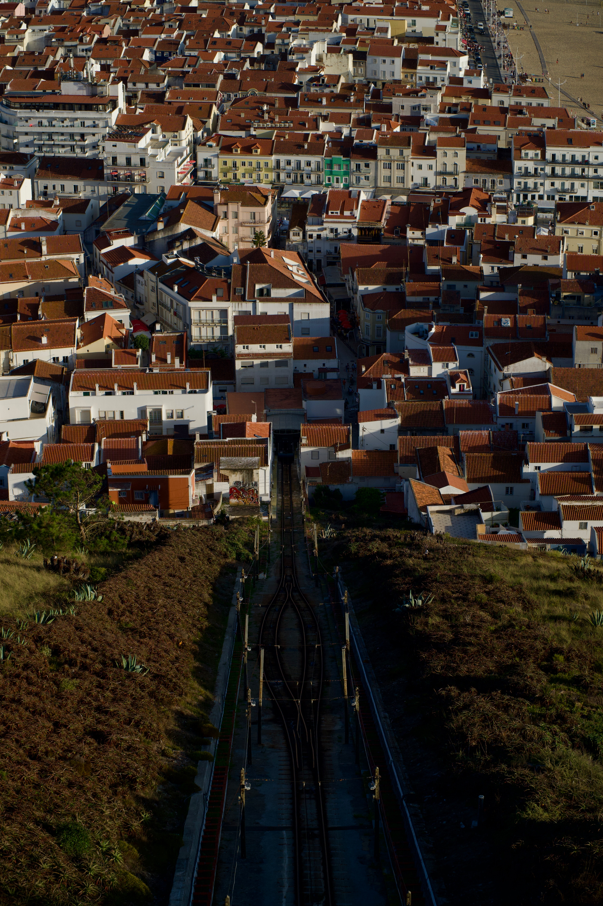 Where red roofs meet the ocean and quiet moments linger above the shore