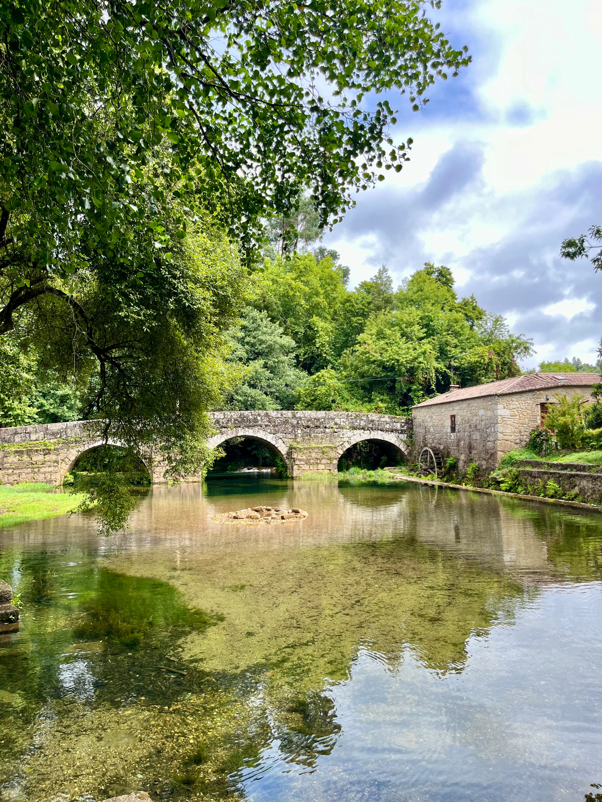 Where stone bridges hold centuries and water holds reflections